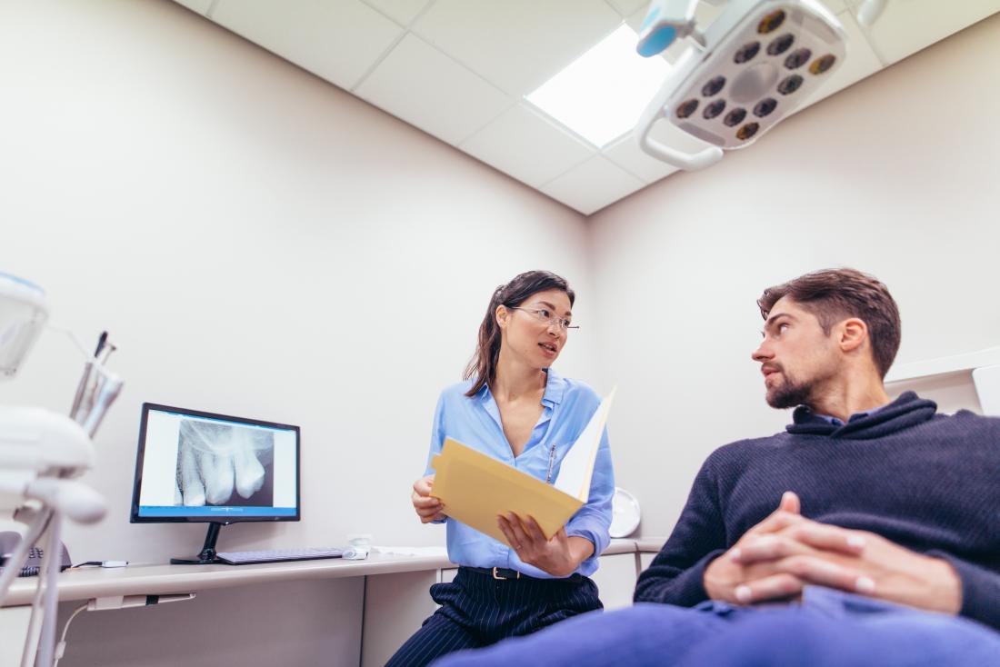 Dentist discussing teeth x-ray with patient.