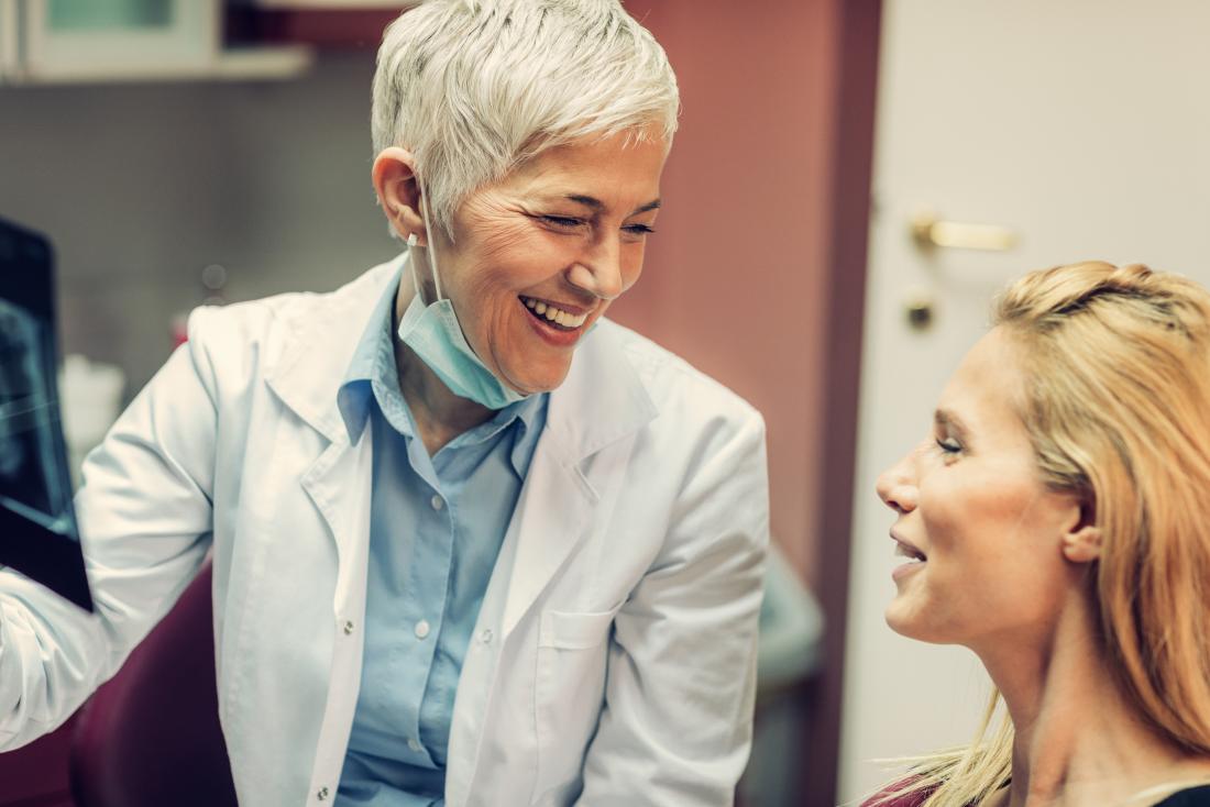 Dentist with patient laughing and smiling.