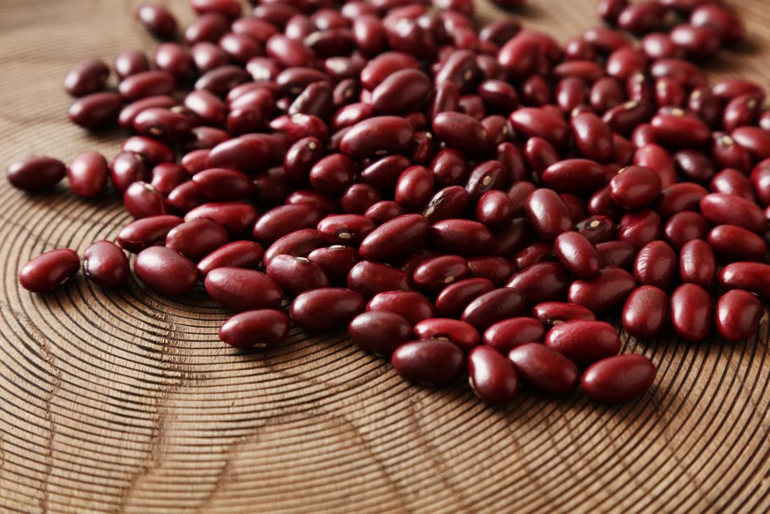 Kidney beans scattered on wooden surface.