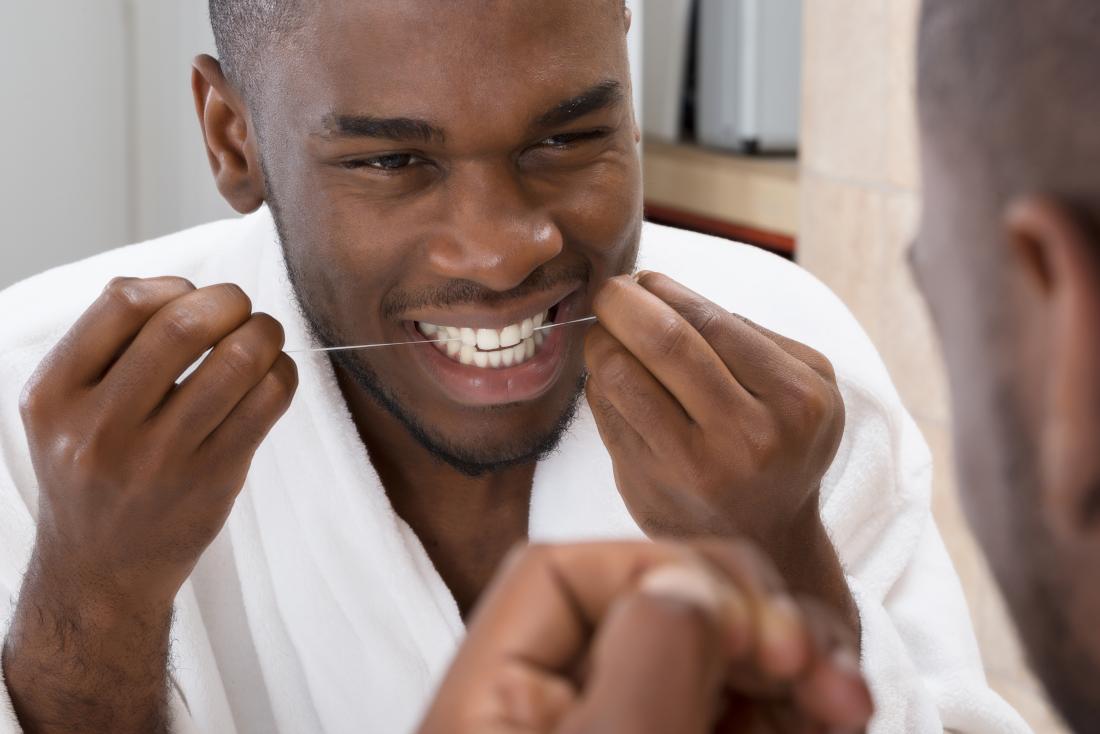 man flossing in the mirror