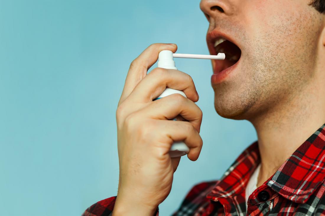 Man using throat spray.