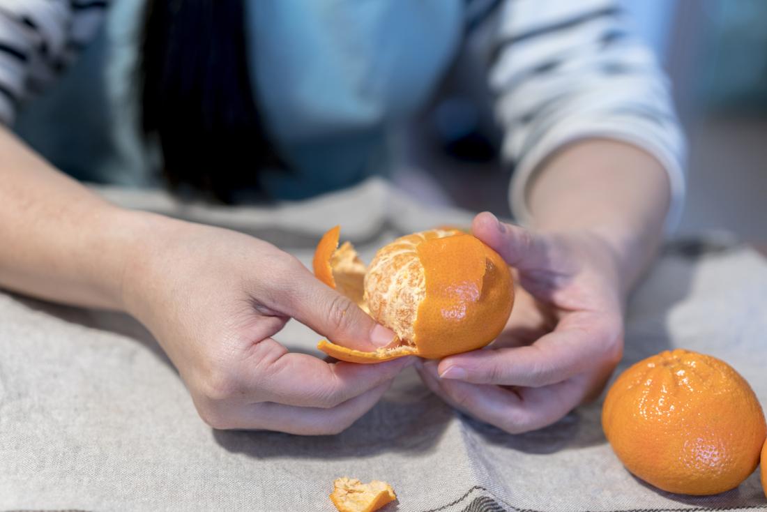 person peeling a satsuma