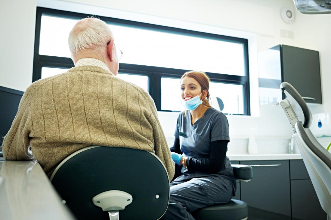 Senior patient speaking to young dentist.