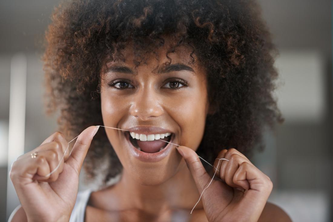 woman flossing her teeth