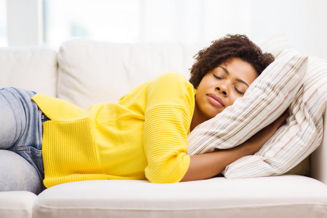 [woman in yellow sweater sleeping on the couch]