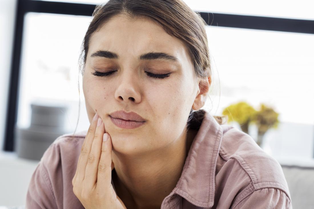 Woman with toothache holding her cheek